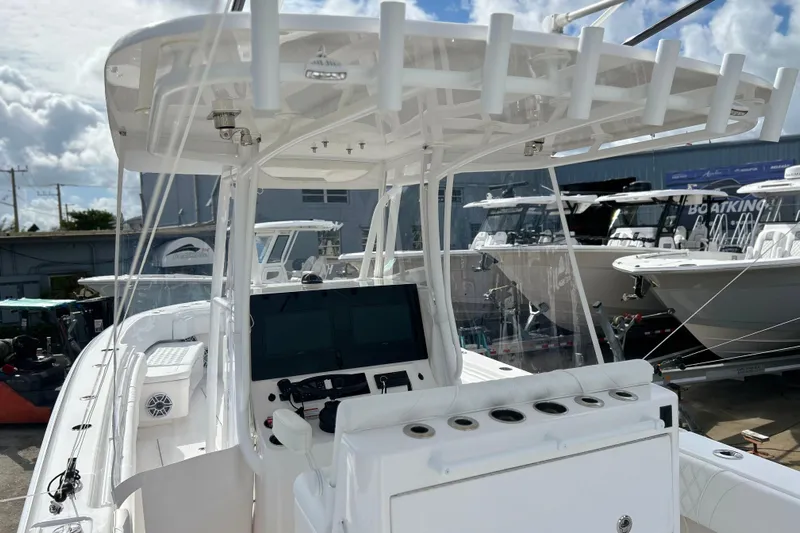  Yacht Photos Pics 2025 Contender 35 ST boat with advanced helm and rod holders, docked under a cloudy sky.