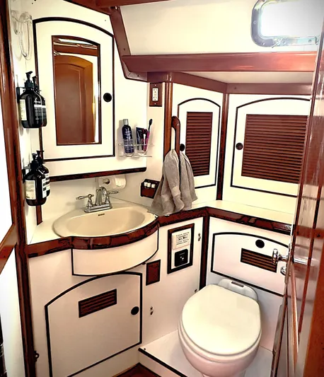 Alice Yacht Photos Pics 1983 Little Harbor 44 yacht bathroom with sink, toilet, and wooden cabinetry.