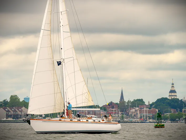 Alice Yacht Photos Pics Sailing yacht Little Harbor 44, 1983, cruising near a coastal town under cloudy skies.
