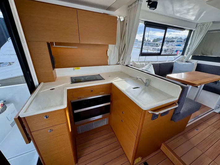Freedom Yacht Photos Pics Modern kitchen in 2022 Beneteau Swift Trawler 41 Fly, featuring wood cabinetry and sleek countertops.