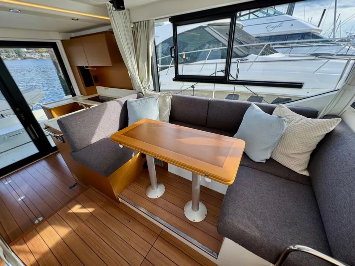 Freedom Yacht Photos Pics Interior of 2022 Beneteau Swift Trawler 41 Fly with elegant seating and wooden table.