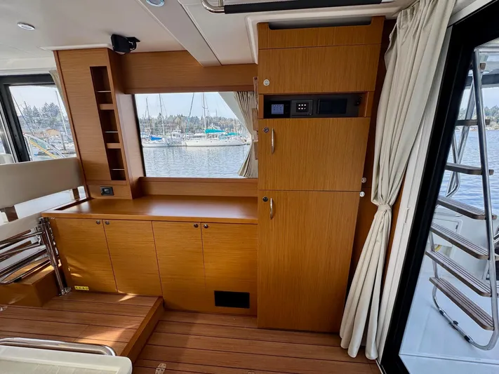 Freedom Yacht Photos Pics 2022 Beneteau Swift Trawler 41 Fly interior with wood cabinetry and window view of marina.