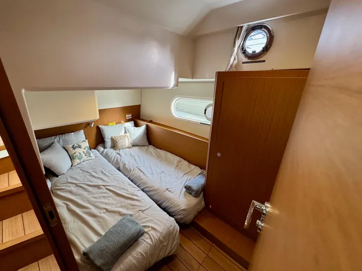 Freedom Yacht Photos Pics 2022 Beneteau Swift Trawler 41 Fly cabin with twin beds and porthole window.