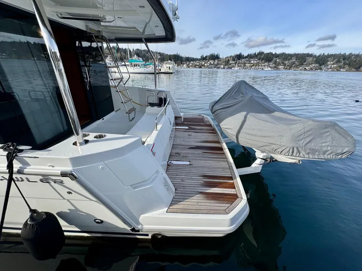 Freedom Yacht Photos Pics Beneteau Swift Trawler 41 Fly 2022, rear deck view with covered equipment, docked on calm water.