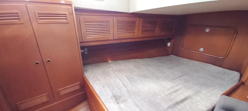 Oya Yacht Photos Pics Wooden interior cabin of 1989 Van De Stadt 52 yacht with bed and storage.