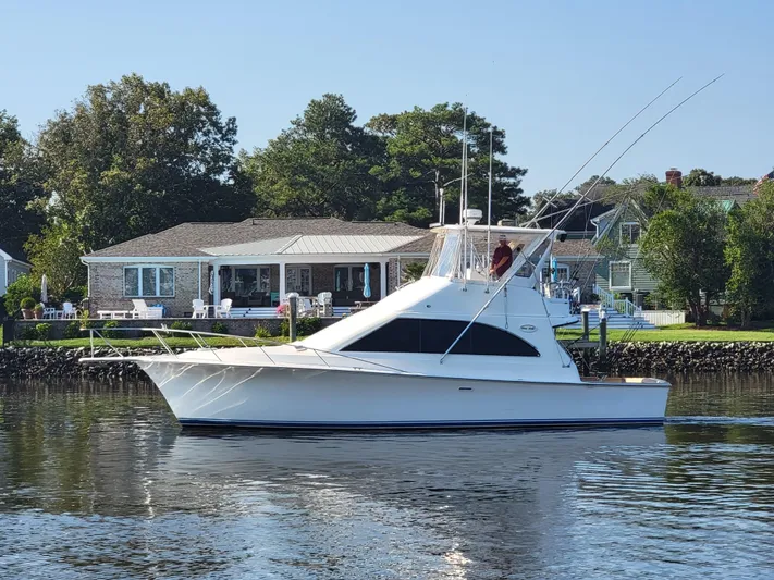  Yacht Photos Pics 1991 Ocean Yachts 42 Super Sport cruising on a calm river near waterfront homes.