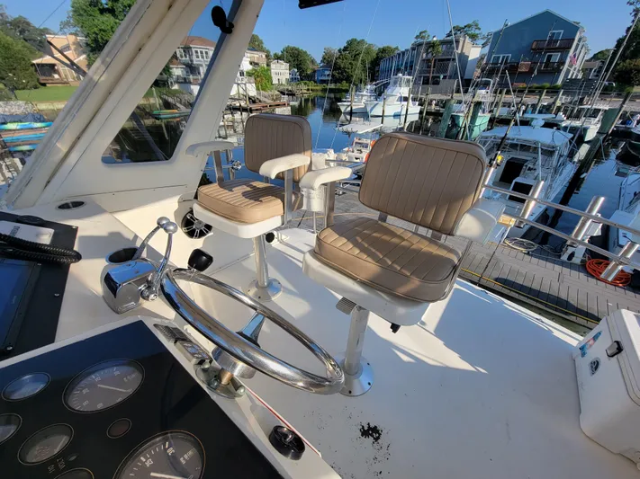  Yacht Photos Pics Cockpit view of 1991 Ocean Yachts 42 Super Sport with helm chairs and marina background.