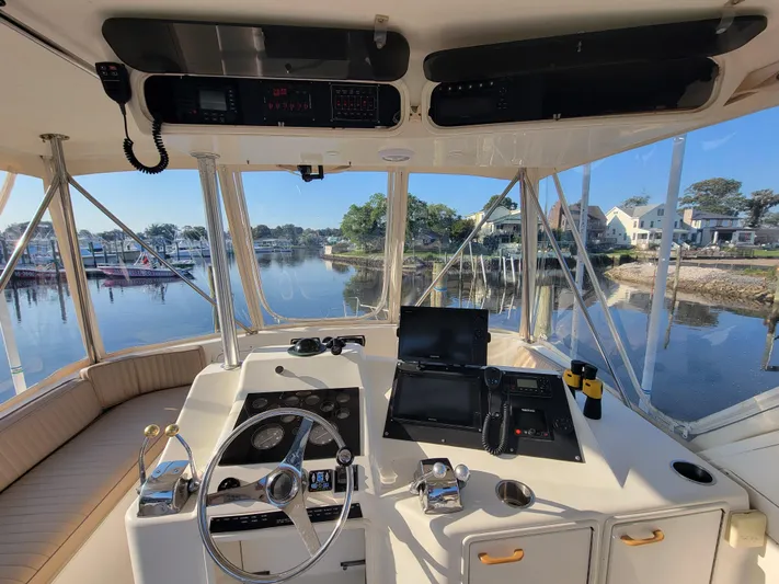  Yacht Photos Pics Cockpit view of a 1991 Ocean Yachts 42 Super Sport, docked in a serene marina.