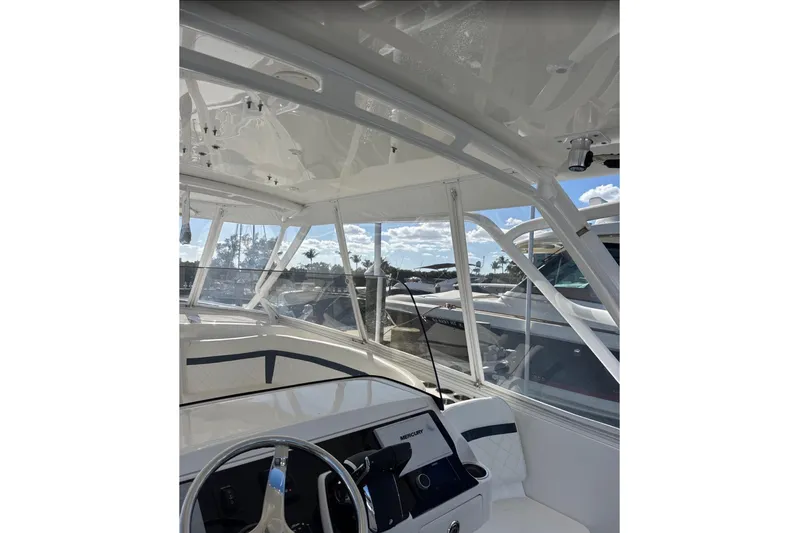  Yacht Photos Pics 2015 Intrepid 400 Cuddy boat interior with steering wheel and clear canopy.