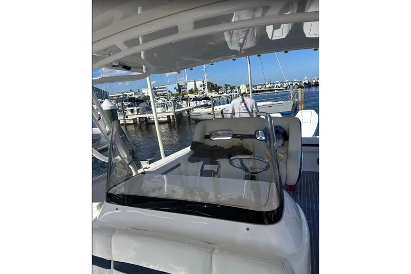  Yacht Photos Pics 2015 Intrepid 400 Cuddy boat interior at marina, showcasing helm and seating area.
