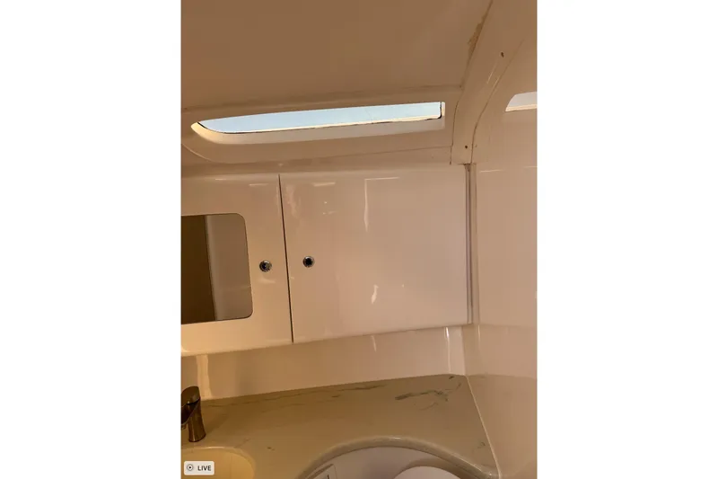  Yacht Photos Pics Interior of 2015 Intrepid 400 Cuddy boat, featuring sleek cabinetry and a small window.