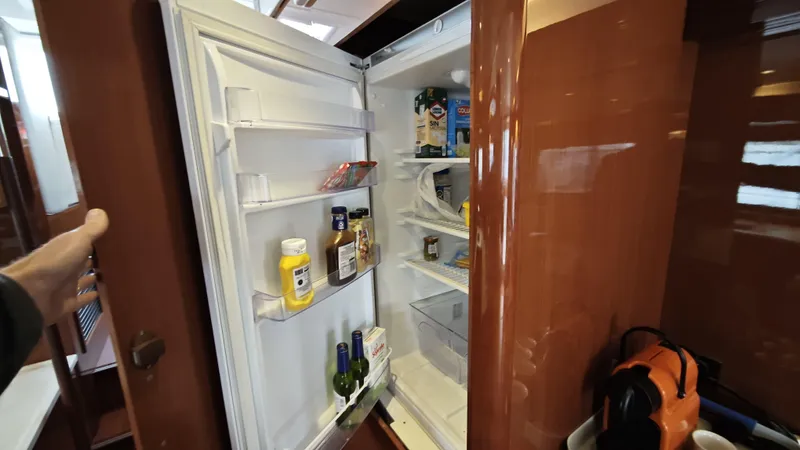 Beneteau Swift Trawler 52 Yacht Photos Pics Open refrigerator inside 2011 Beneteau Swift Trawler 52, stocked with condiments and beverages.