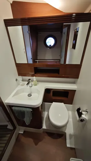 Beneteau Swift Trawler 52 Yacht Photos Pics Bathroom interior of 2011 Beneteau Swift Trawler 52 with sink, toilet, and porthole window.