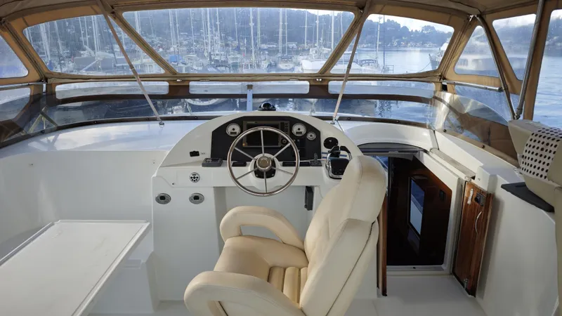 Beneteau Swift Trawler 52 Yacht Photos Pics Helm of 2011 Beneteau Swift Trawler 52 with beige seating and panoramic windows.