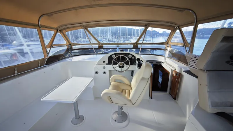 Beneteau Swift Trawler 52 Yacht Photos Pics Helm of 2011 Beneteau Swift Trawler 52 with beige seating and panoramic windows.