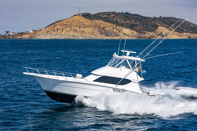 Whiplash II Yacht Photos Pics 2006 Hatteras 50 Convertible yacht cruising near a rocky coastline.