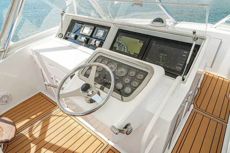 Whiplash II Yacht Photos Pics Helm of 2006 Hatteras 50 Convertible yacht with modern navigation instruments and wooden flooring.