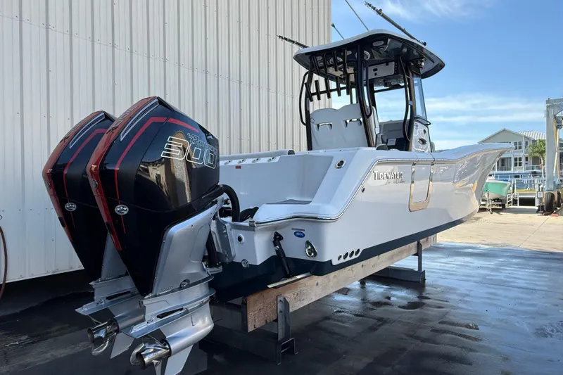  Yacht Photos Pics 2022 Tidewater 292 CC Adventure boat with twin outboard engines, docked outdoors.