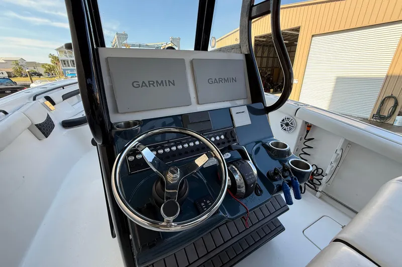  Yacht Photos Pics 2022 Tidewater 292 CC Adventure boat dashboard with Garmin displays and steering wheel.