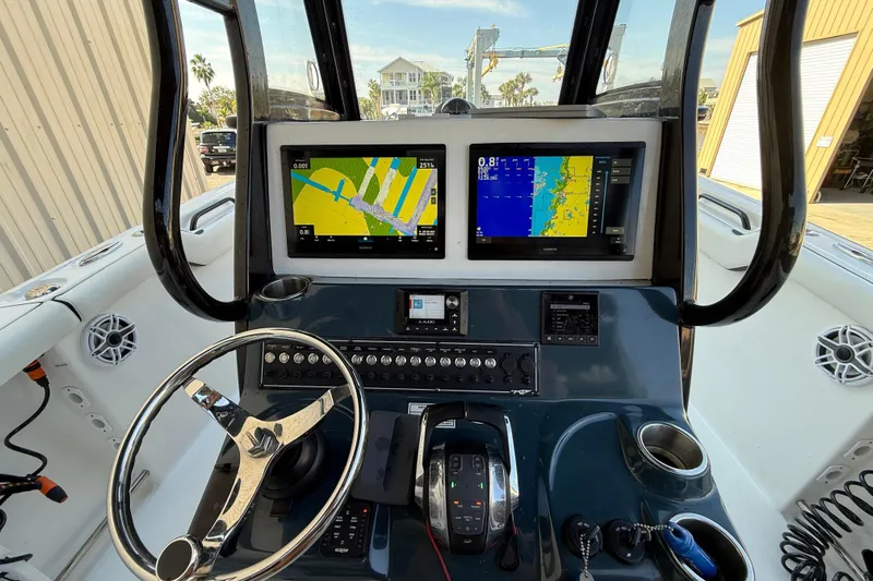 Yacht Photos Pics 2022 Tidewater 292 CC Adventure boat dashboard with dual navigation screens and steering wheel.