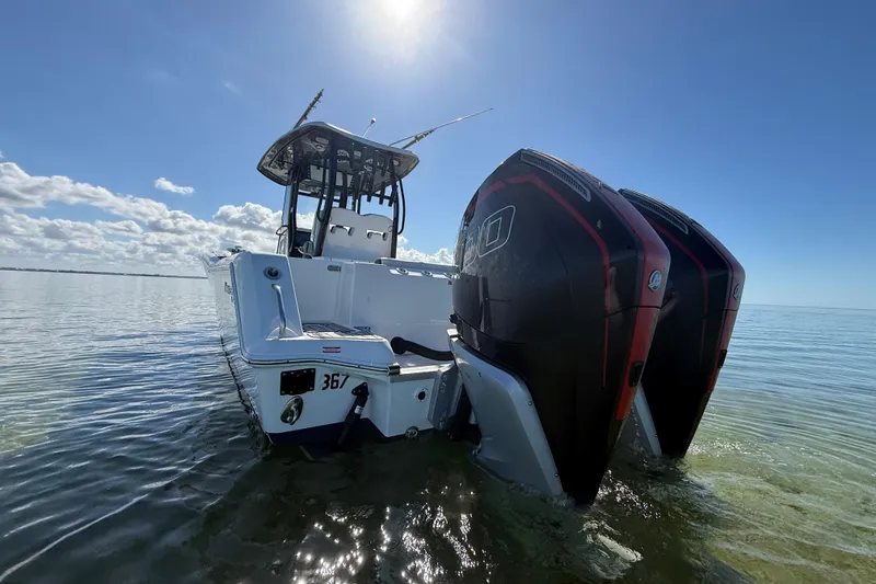  Yacht Photos Pics 2022 Tidewater 292 CC Adventure boat with dual engines in shallow water under clear sky.