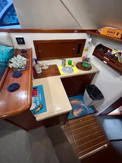  Yacht Photos Pics 2002 Riviera Convertible 37 yacht interior with compact kitchen and wooden accents.