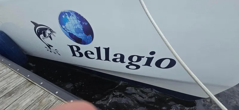 Bellagio Yacht Photos Pics Kelsall Suncat 40 boat named "Bellagio" docked, featuring globe and fish graphics.