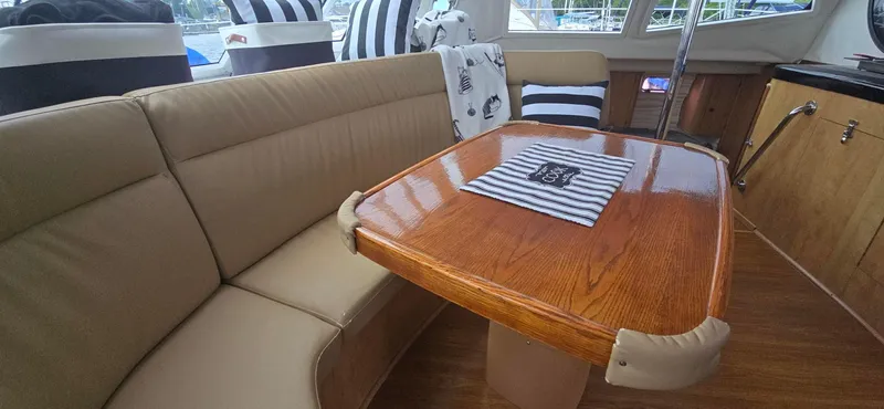 Bellagio Yacht Photos Pics Interior of 2013 Kelsall Suncat 40 with wooden table and beige seating.