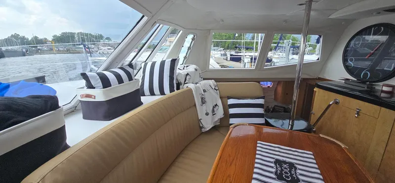 Bellagio Yacht Photos Pics Interior of 2013 Kelsall Suncat 40 yacht with striped cushions and wooden table.