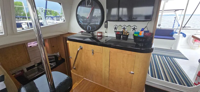 Bellagio Yacht Photos Pics Interior of 2013 Kelsall Suncat 40 yacht with clock and striped rug.