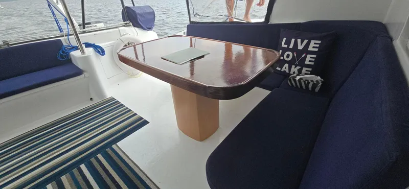 Bellagio Yacht Photos Pics Kelsall Suncat 40 yacht interior with blue seating, wooden table, and striped rug, 2013 model.