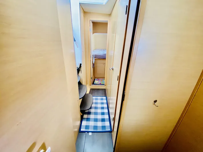 Finally Found Yacht Photos Pics Narrow hallway inside 2014 Lagoon 380 S2 yacht with wooden interior and checkered rug.