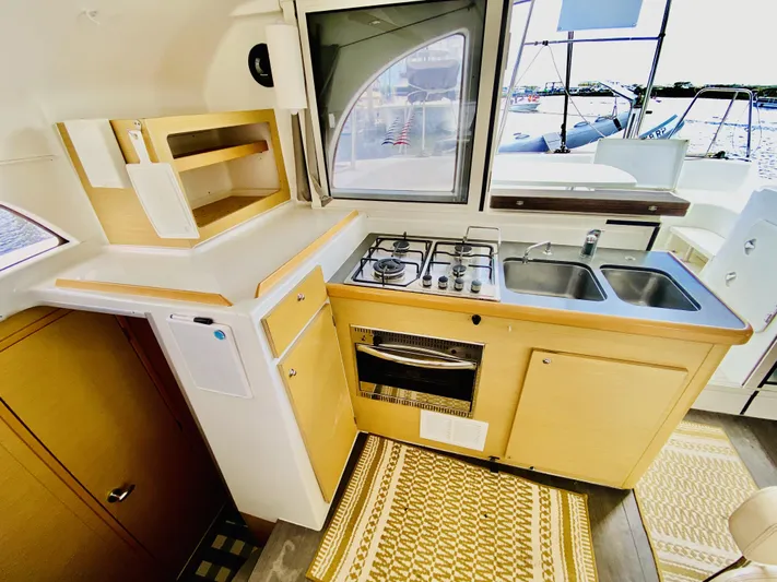 Finally Found Yacht Photos Pics Compact kitchen in a 2014 Lagoon 380 S2 catamaran with stove, sink, and storage.