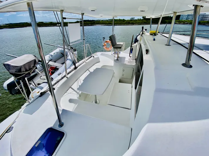 Finally Found Yacht Photos Pics 2014 Lagoon 380 S2 catamaran deck with seating, docked by calm waters.