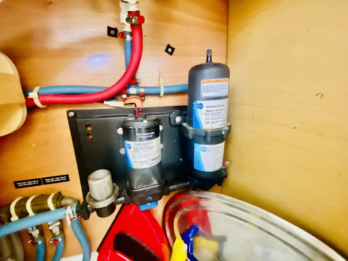 Finally Found Yacht Photos Pics 2014 Lagoon 380 S2 yacht plumbing system with filters and pipes in a wooden compartment.