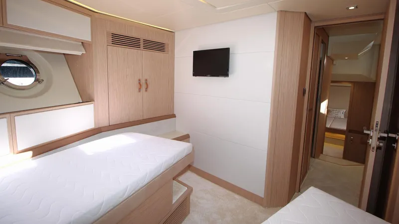  Yacht Photos Pics Luxurious cabin interior of 2015 Beneteau Monte Carlo 6 yacht with twin beds and TV.