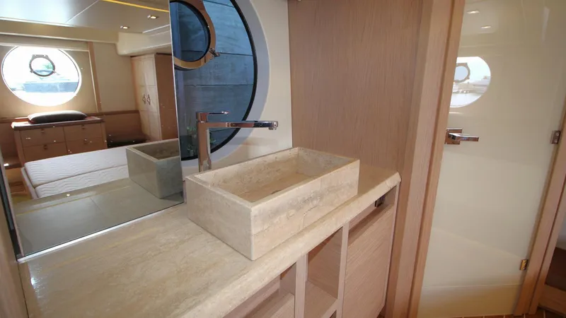  Yacht Photos Pics Luxurious bathroom interior on 2015 Beneteau Monte Carlo 6 yacht, featuring modern sink and porthole window.