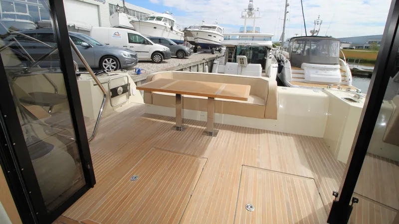  Yacht Photos Pics Spacious deck of 2015 Beneteau Monte Carlo 6 yacht, featuring elegant wood flooring and seating.