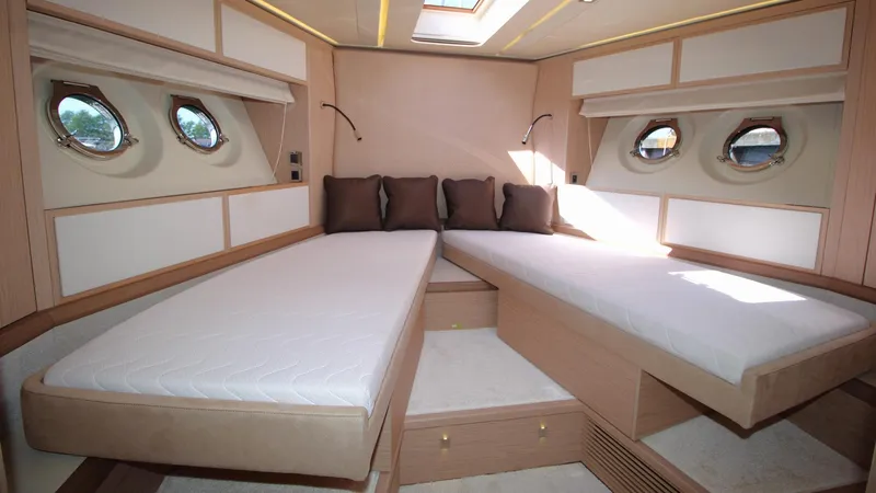  Yacht Photos Pics Luxurious cabin interior of 2015 Beneteau Monte Carlo 6 yacht with twin beds and portholes.