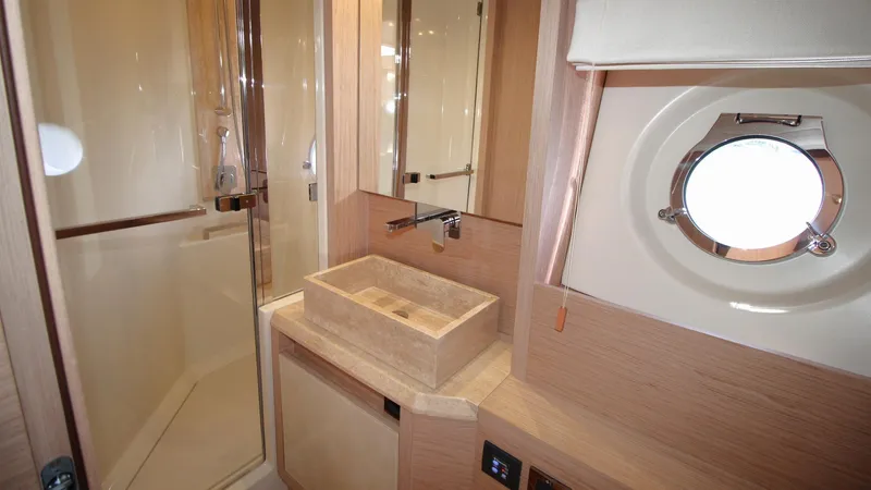  Yacht Photos Pics Luxurious bathroom in 2015 Beneteau Monte Carlo 6 yacht with modern fixtures and porthole window.