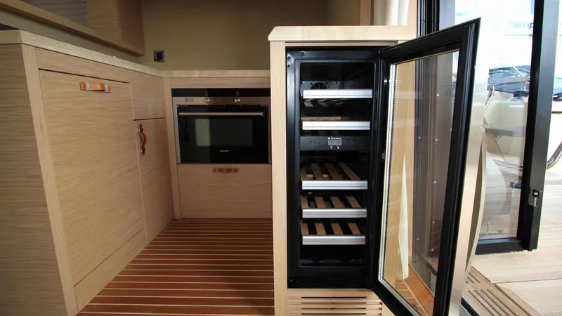  Yacht Photos Pics Luxurious kitchen interior of 2015 Beneteau Monte Carlo 6 yacht with open wine cooler.