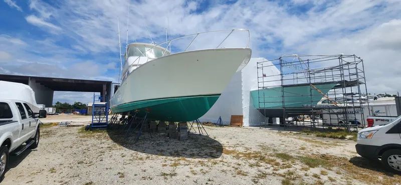  Yacht Photos Pics 2004 Viking 52 Convertible boat on dry dock for maintenance under a partly cloudy sky.