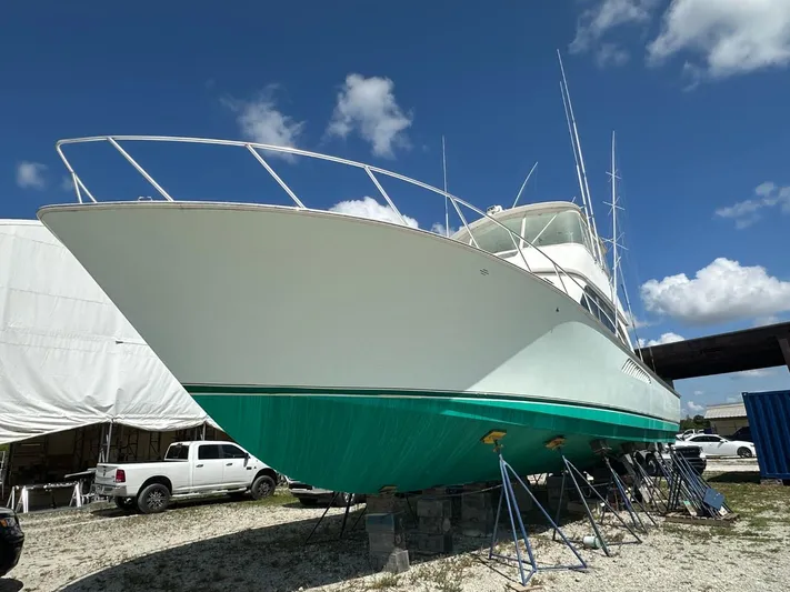  Yacht Photos Pics 2004 Viking 52 Convertible yacht on dry dock under a clear blue sky.
