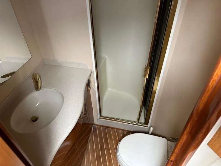  Yacht Photos Pics Bathroom interior of a 2004 Viking 52 Convertible yacht with shower, sink, and toilet.