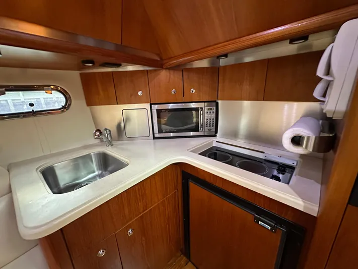  Yacht Photos Pics 2005 Tiara Yachts 3600 Sovran kitchen with sink, microwave, and stove.