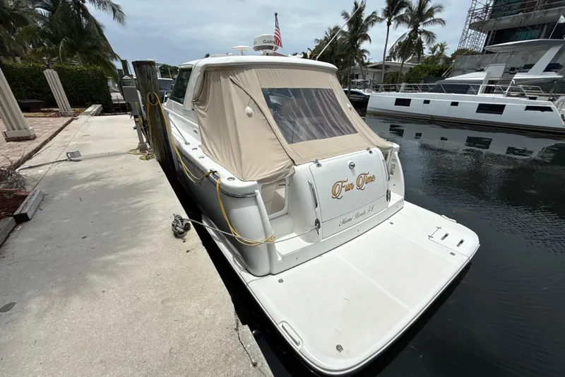  Yacht Photos Pics 2005 Tiara Yachts 3600 Sovran docked, rear view with beige cover, palm trees in background.