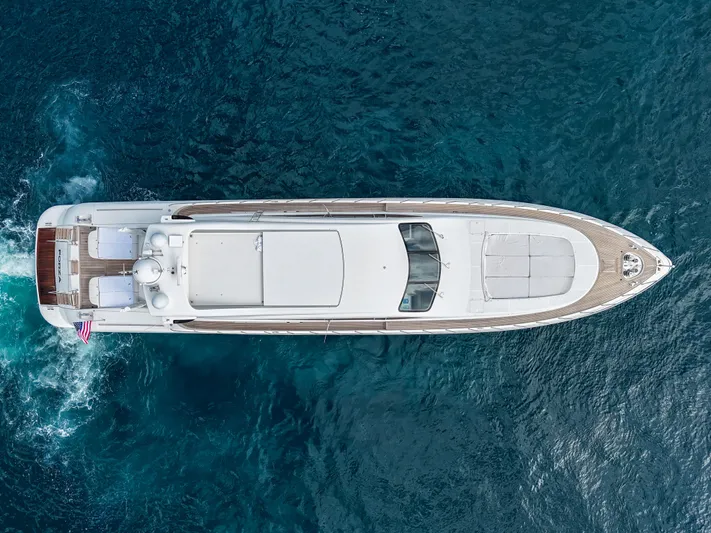  Yacht Photos Pics Aerial view of 2002 Mangusta 108 yacht cruising on blue ocean waters.