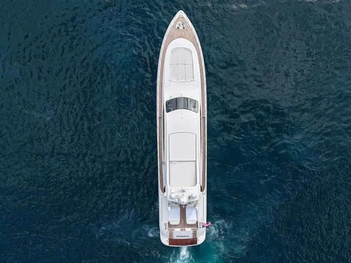  Yacht Photos Pics Aerial view of 2002 Mangusta 108 yacht cruising on deep blue ocean waters.