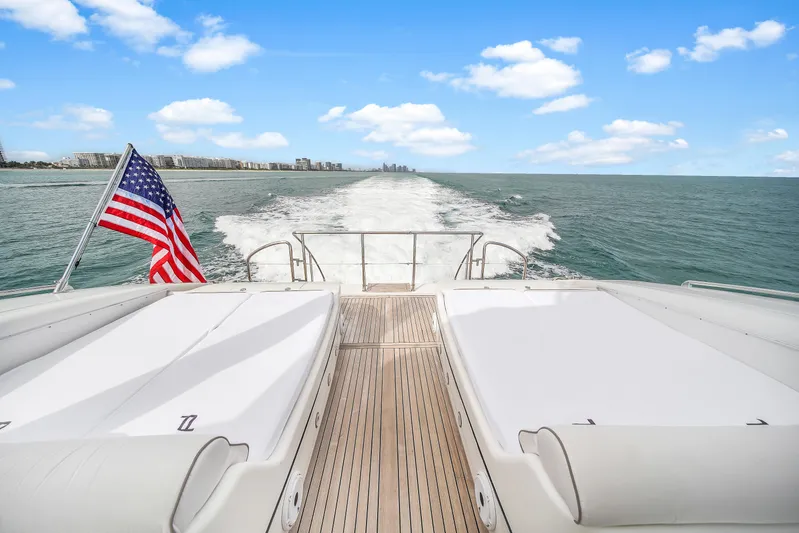  Yacht Photos Pics Mangusta 108 yacht cruising on open water, American flag waving, 2002 model.