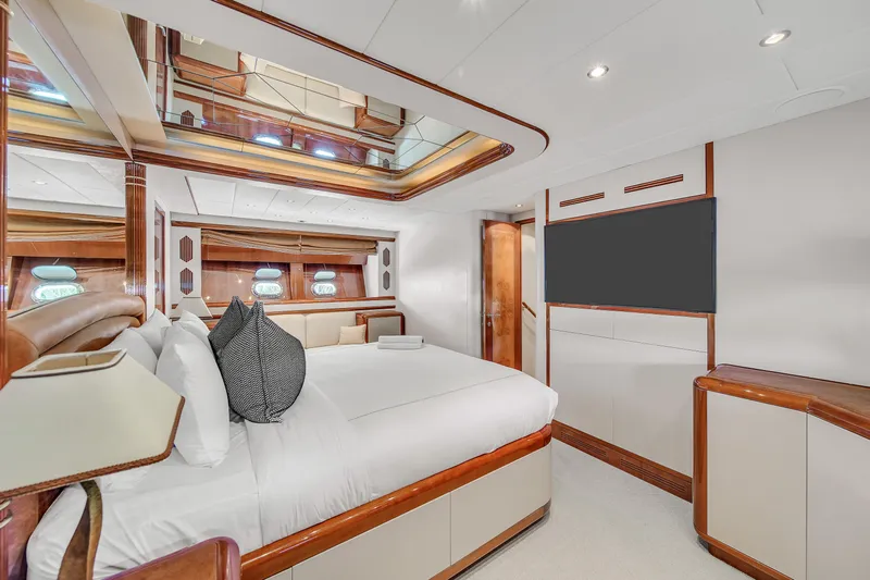  Yacht Photos Pics Luxurious bedroom interior of 2002 Mangusta 108 yacht with elegant wood accents.